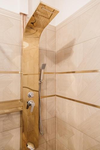 a shower with a shower head in a bathroom at Villa Apartman in Makó