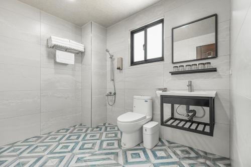 a white bathroom with a toilet and a mirror at Xiao San Chill in Xiaoliuqiu