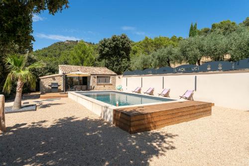 une piscine avec des chaises et une maison dans l'établissement Mas de l'Acqueduc, à Le Barroux