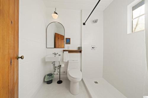 a white bathroom with a toilet and a sink at Triangle Motel in Red Bluff
