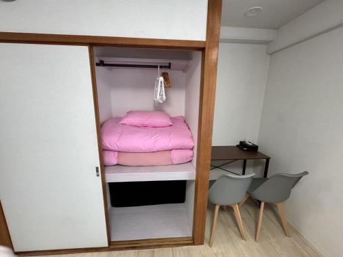 a small room with a bunk bed and two chairs at プレストスクエア松島町 in Takamatsu