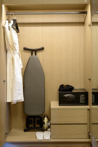 a room with a closet with a dresser and a robe at The Granite Luxury Hotel Penang in George Town