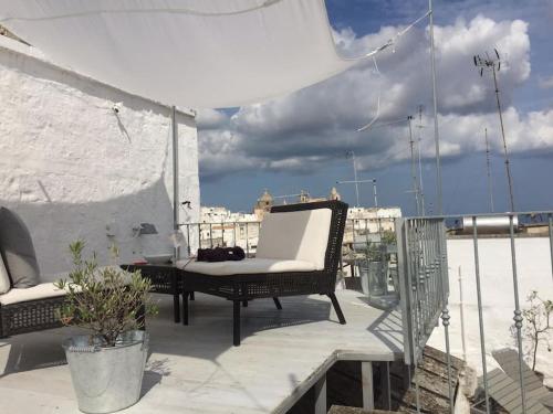 a patio with two wicker chairs on a balcony at Casa Libertà Spacious white scandidesign in Ostuni