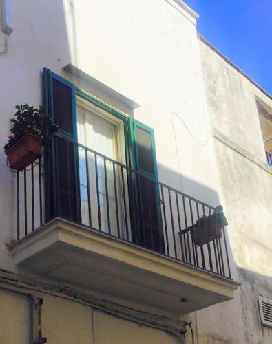a balcony with a window and two plants on it at Casa Libertà Spacious white scandidesign in Ostuni