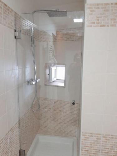 a bathroom with a shower with a window at Casa Libertà Spacious white scandidesign in Ostuni