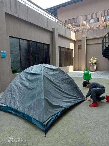 a man is playing with a tent in front of a building at Taj Guras Kutir Resort & Spa, Gangtok in Gangtok