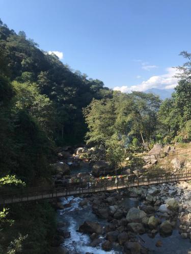 a bridge over a river next to a mountain at Taj Guras Kutir Resort & Spa, Gangtok in Gangtok