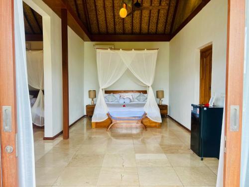 a bedroom with a bed with a mosquito net at Gayatri in Ubud