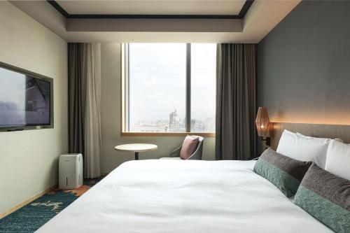 a hotel room with a bed and a large window at Solaria Nishitetsu Hotel Taipei Ximen in Taipei