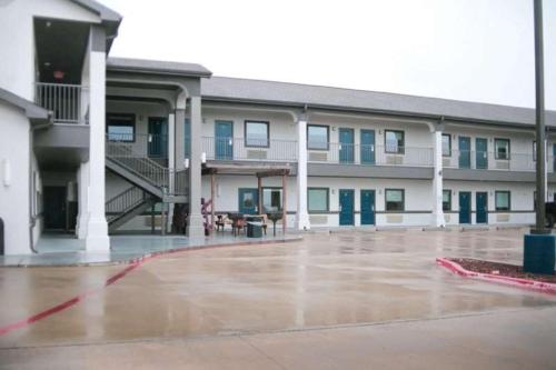 a large building with a patio in front of it at Days Inn & Suites by Wyndham Gonzales TX in Gonzales