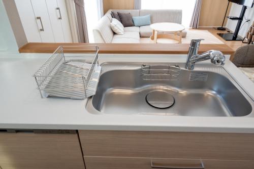 a kitchen sink with a dish drying rack on it at ライトハウス旭川 in Asahikawa