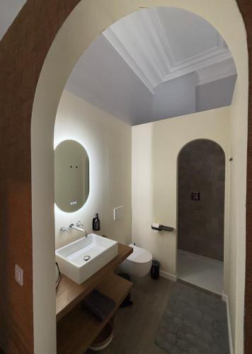 an arched bathroom with a sink and a toilet at B&B Het Havenhuis in Bruges