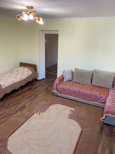 a living room with two beds and a couch at Гостевой дом "Светлана" in Cholpon-Ata