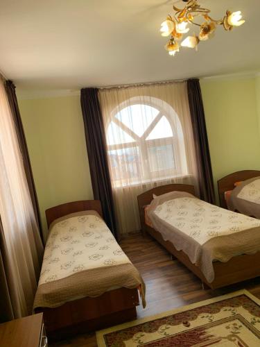 a bedroom with two beds and a window at Гостевой дом "Светлана" in Cholpon-Ata