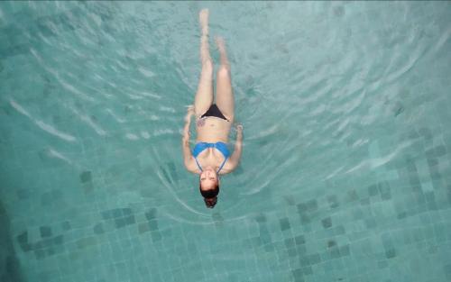 a woman laying in the water in a swimming pool at AHAS GAWWA Boutique in Padukka