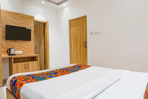 a bedroom with a bed with a colorful blanket at FabHotel Pancharatna Regency - Nr Medicover Hospital in Pune
