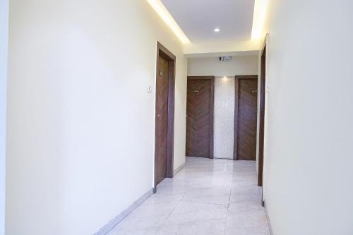 a hallway with white walls and wooden doors at FabHotel Pancharatna Regency - Nr Medicover Hospital in Pune