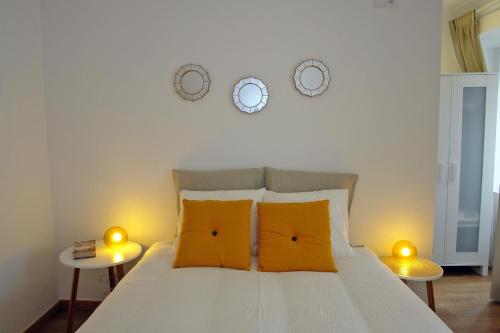 a bedroom with a bed with two tables and two clocks at Cascais 4 You in Cascais
