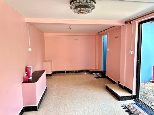 an empty room with pink walls and a table at Garden Bungalows Koh Rong in Koh Rong