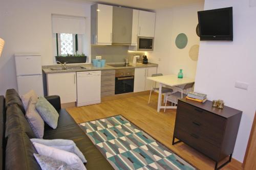 a living room with a couch and a kitchen at Cascais 4 You in Cascais