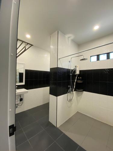 a bathroom with a shower with black and white tiles at Ta-iad homestay at Soi Ta-iad in Ban Suan