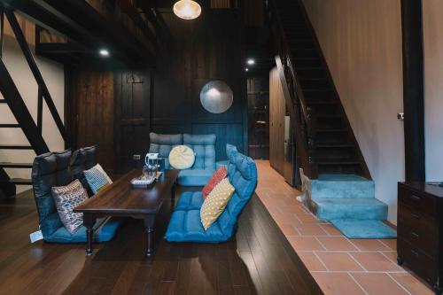 a living room with a blue couch and a table at 洛津做夢-鹿港包棟民宿 Lok-tin Choe-bang House in Lugang