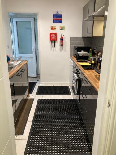 a kitchen with a black and white floor at Meadow Street Rooms in Avonmouth