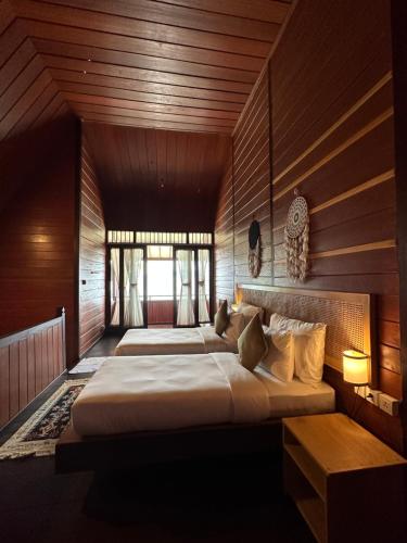 1 Schlafzimmer mit 2 Betten in einem Zimmer mit Holzwänden in der Unterkunft Yenatar Resort in Friwin