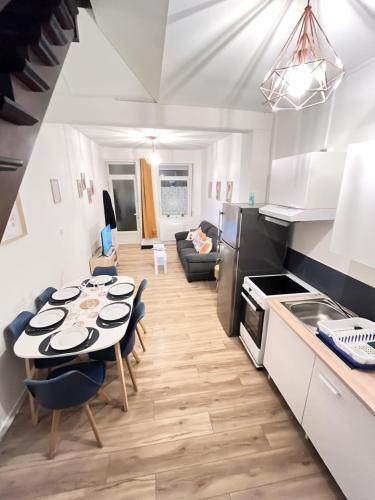 une cuisine et un salon avec une table et des chaises dans l'établissement Le Duplex 3 chambres entrée privée, à Calais
