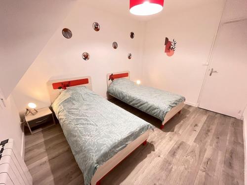 - une chambre avec 2 lits et un mur orné d'objets dans l'établissement Le Duplex 3 chambres entrée privée, à Calais