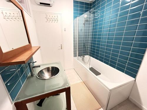 La petite salle de bains est pourvue d'un lavabo et d'une baignoire. dans l'établissement Le Duplex 3 chambres entrée privée, à Calais