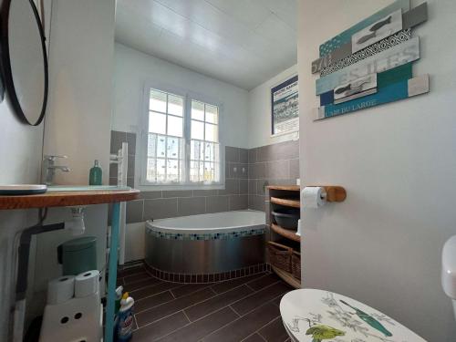 La salle de bains est pourvue d'une baignoire et de toilettes. dans l'établissement Mais 5 pièces CHATELAILLON PLAGE - CL000-085, à Châtelaillon-Plage