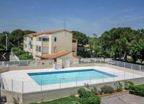 une grande piscine devant une maison dans l'établissement Petite maison sympa dans résidence avec piscine, à Saint-Cyprien