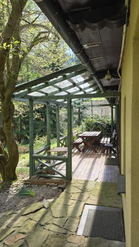 a covered deck with picnic tables and a tree at Łapszanka 29 in Łapszanka
