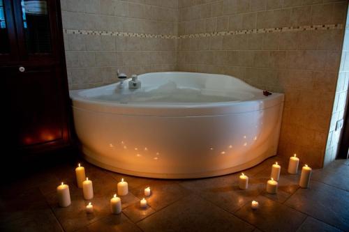 a bathroom with a bath tub with candles on the floor at Tenuta Ulivi in Putignano