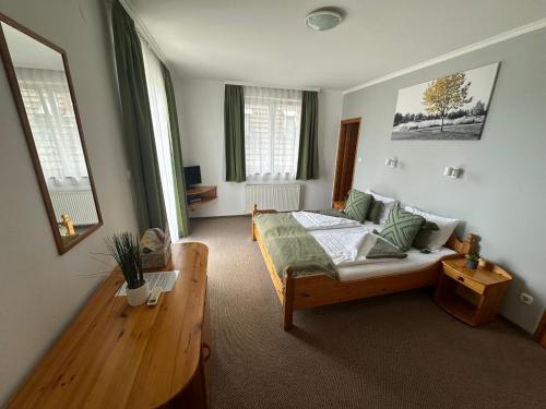 a bedroom with a bed and a table and windows at VillaBoglár in Balatonboglár
