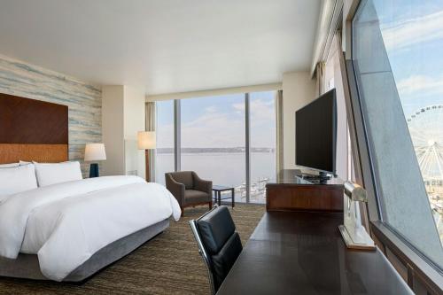 a hotel room with a large bed and a large window at The Westin Washington National Harbor in National Harbor