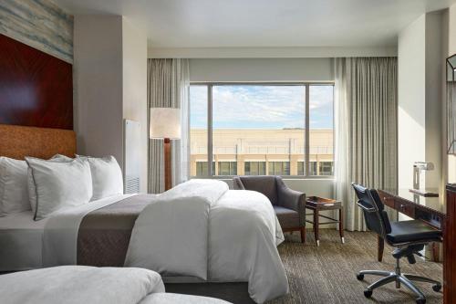 a hotel room with a bed and a desk and a window at The Westin Washington National Harbor in National Harbor