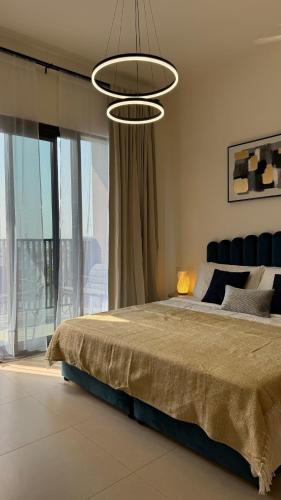 a bedroom with a large bed and a chandelier at Светлая и просторная квартира in Sharjah