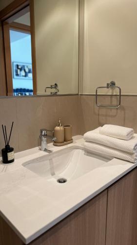 a bathroom with a white sink and a mirror at Светлая и просторная квартира in Sharjah