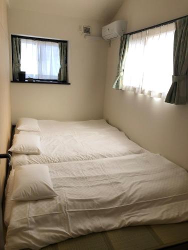 a bedroom with two beds and a window at 花見宿hanamiyado叡電eiden木野kino-木野駅徒歩1分1minutes walk from kinostation-衣類乾燥機有-無料駐車場有-宿泊税込 in Kyoto