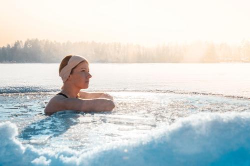 a woman swimming in a body of water at Spa Hotel Kunnonpaikka in Kuopio