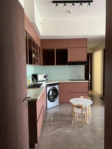 a kitchen with a table and a washing machine at Swanbay in Cù Lao Ong Con