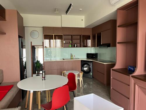 a kitchen with a white table and red chairs at Swanbay in Cù Lao Ong Con