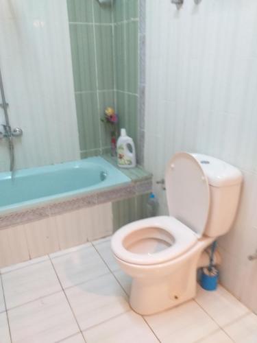 a bathroom with a toilet and a bath tub at Mourad morsy مراد in Najâ€˜ al MadÄbb