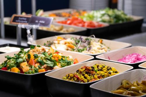 a buffet filled with different types of food in trays at Spa Hotel Kunnonpaikka in Kuopio
