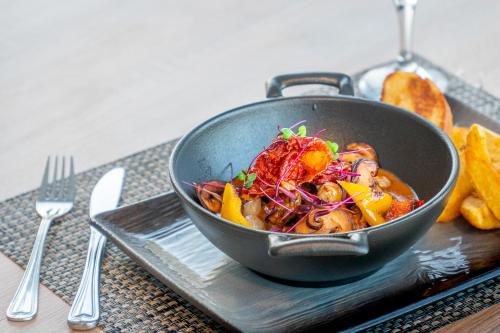 a pan of food on a plate with some food at Spa Hotel Kunnonpaikka in Kuopio