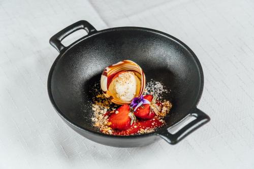 a black pan with food in it on a table at Spa Hotel Kunnonpaikka in Kuopio