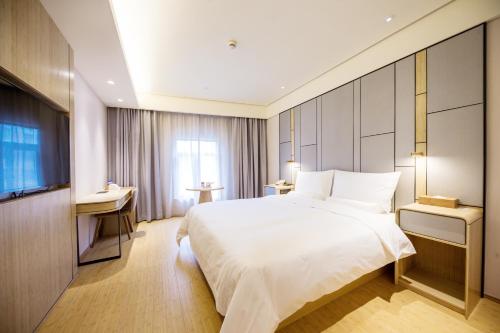 a hotel room with a large bed and a television at Ji Hotel Shanghai The Bund Jinling East Road in Shanghai