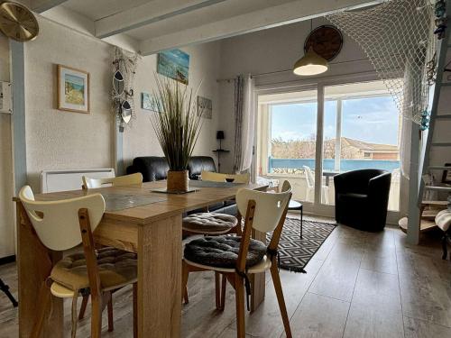 une salle à manger avec une table et des chaises avec vue sur l'océan dans l'établissement Appartement 3 pièces 4 couchages SAINT-PIERRE D'OLERON SPO000-160, à Saint-Pierre-dʼOléron